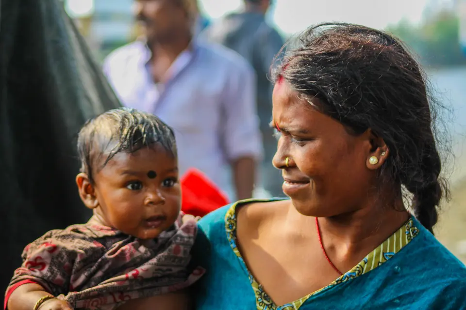 a mother in Kolkata carries and cradles her baby close